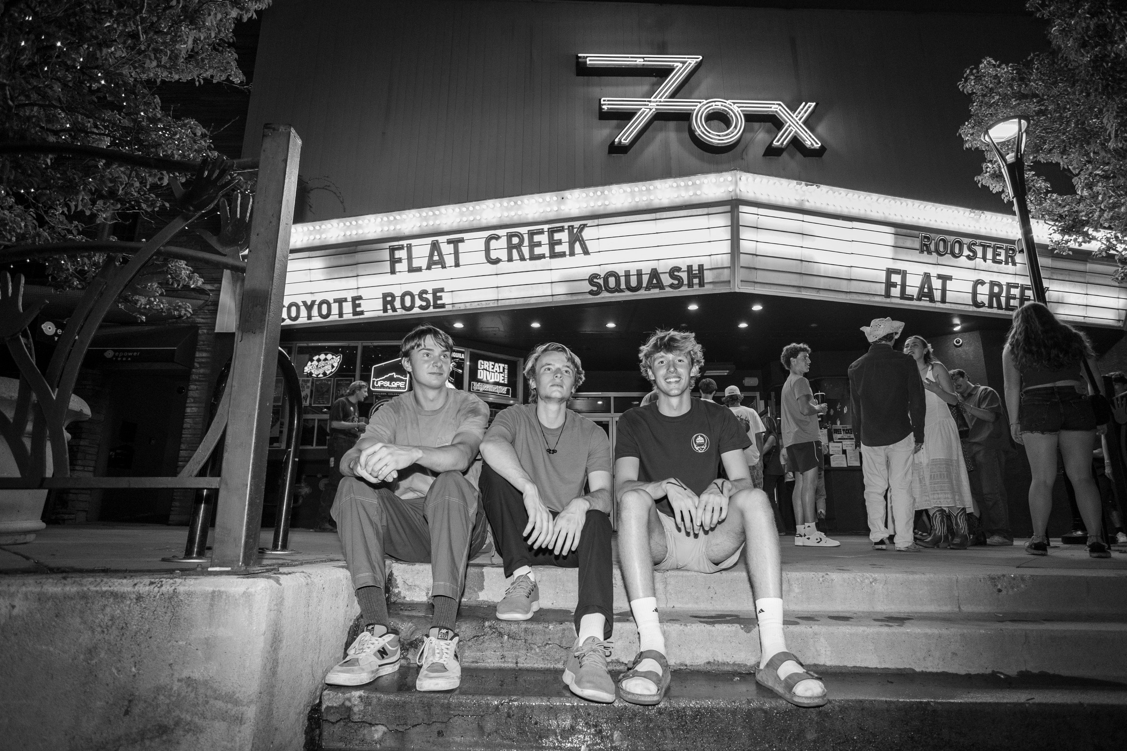Squash trio performing under the marquee lights at the Fox Theatre in Boulder